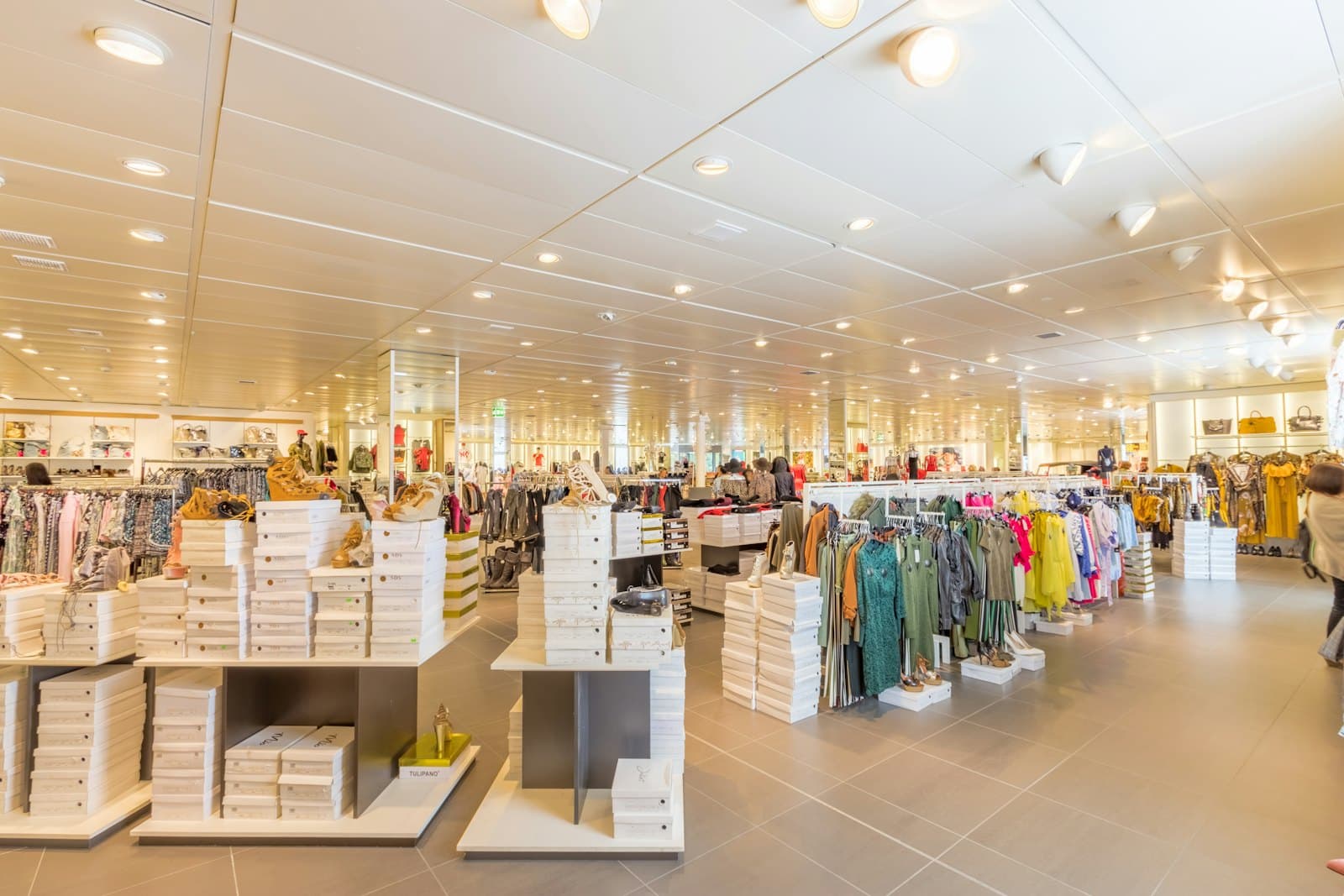 Bright, tidy retail store floor with clothing rails